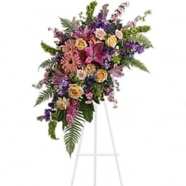 Tall floral spray on a white easel with pink, purple, and yellow blooms