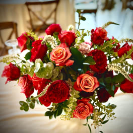 Rounded arrangement of red and orange roses on a table