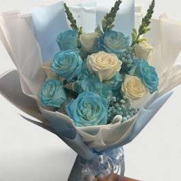 Bouquet of blue and white roses wrapped in pale paper
