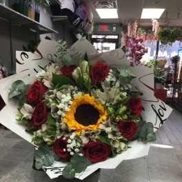 Bouquet of red roses and a sunflower with white flowers