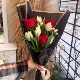 Bouquet of red roses and white tulips wrapped in black paper