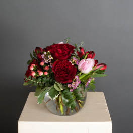 Red and pink flower arrangement in a clear glass vase