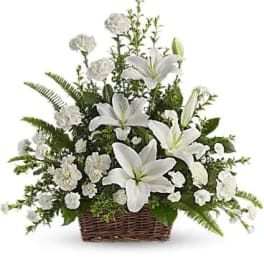 White lilies and carnations in a wicker basket arrangement
