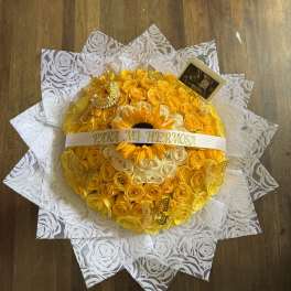 Round bouquet of yellow and white roses with a sunflower center