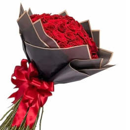 Bouquet of red roses wrapped in dark paper with a red ribbon