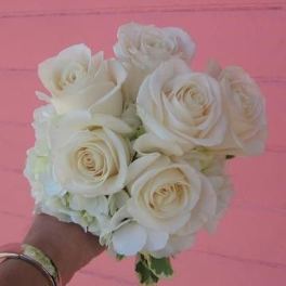 Handheld bouquet of white roses with pale filler flowers