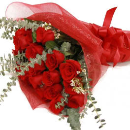 Bouquet of red roses wrapped in red mesh with a ribbon