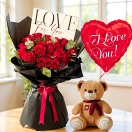 Bouquet of red roses with a teddy bear and heart balloon