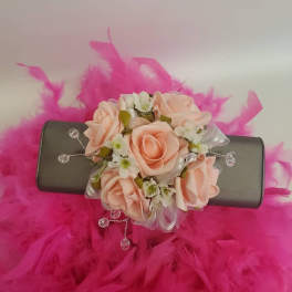 Pink rose corsage on a black wristlet with feather trim