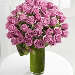 Bouquet of pink roses in a tall green glass vase