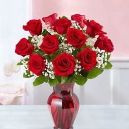 Red roses arranged in a red glass vase