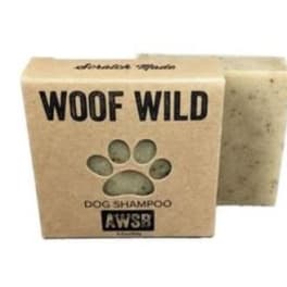 Bar of dog shampoo soap in a kraft box labeled Woof Wild with a paw-shaped cutout