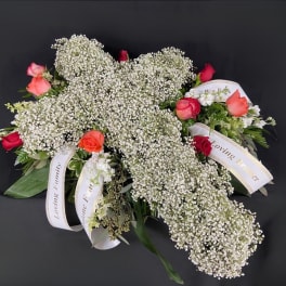 White baby's breath arrangement with red and coral roses and memorial ribbons