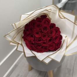 Bouquet of red roses wrapped in white and gold paper