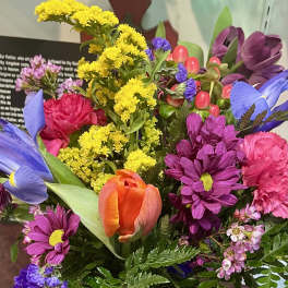 Colorful mixed bouquet with tulips, daisies, carnations, and small filler flowers