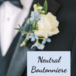 White rose and blue flower boutonniere pinned to a black tuxedo jacket