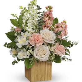 Pink and white floral arrangement in a wooden cube vase