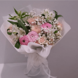 Pink and white mixed bouquet wrapped in white paper with a ribbon