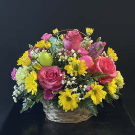 Basket arrangement of pink roses and yellow daisies with colorful balloons
