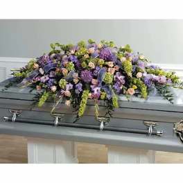 Lavender and peach floral spray on a gray casket
