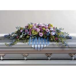 Lavender and blue floral casket spray with ribbon accents