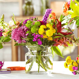 Mixed bouquet of colorful flowers in a clear glass vase