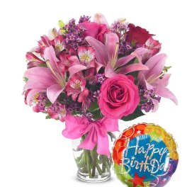 Pink mixed bouquet in a glass vase with a birthday balloon