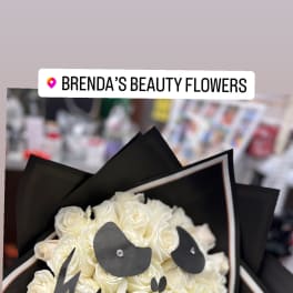Bouquet of white roses wrapped in black paper with a black ribbon