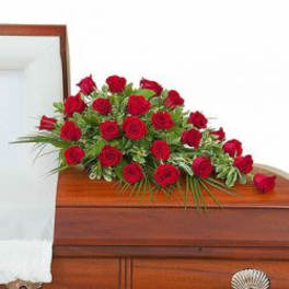 Red rose arrangement on a wooden casket