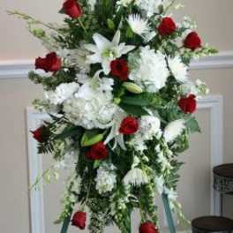 Standing spray of red roses and white lilies on a tripod easel