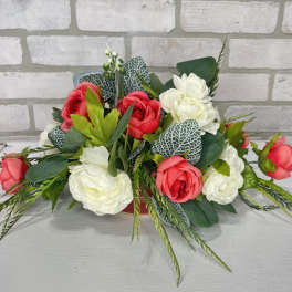 Arrangement of red and white roses with greenery on a table
