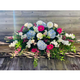 Large floral spray with blue hydrangeas, white blooms, and hot pink daisies