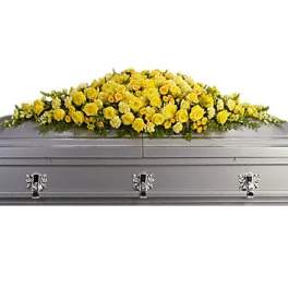 Yellow floral casket spray on a gray casket