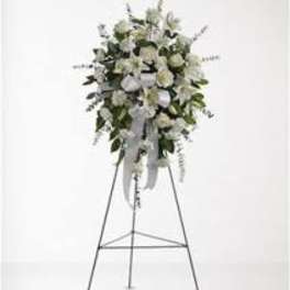 White floral standing spray on an easel with ribbon streamers