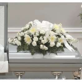 White floral casket spray with a large ribbon on a silver casket