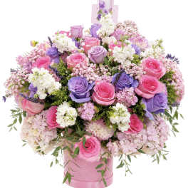 Large bouquet of pink and purple roses in a pink hatbox
