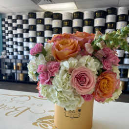 Pink and orange roses with white hydrangeas in a gold box