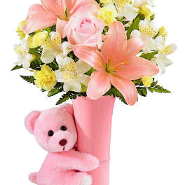Pink and white flower bouquet in a pink vase with a pink teddy bear