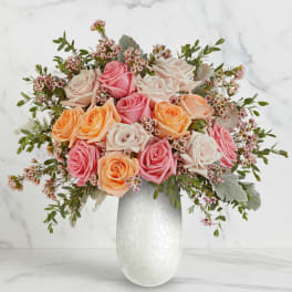 Bouquet of pink, peach, and white roses in a white vase