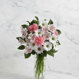 Pink carnations and white daisies in a clear glass vase