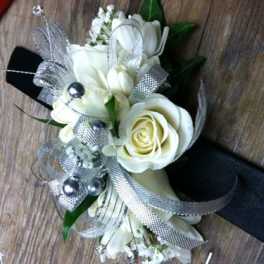 White rose corsage with silver ribbon and pearl accents on a black band
