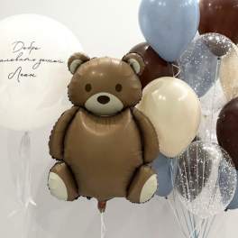 Teddy bear balloon surrounded by blue, brown, white, and clear balloons