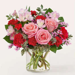 Pink roses and red carnations in a clear glass vase