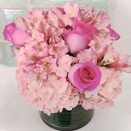 Pink roses and alstroemeria arranged in a glass vase