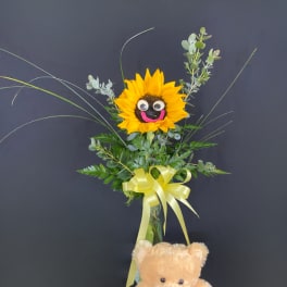 Sunflower arrangement with a teddy bear and yellow ribbon