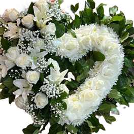 Heart-shaped white floral arrangement with roses and lilies