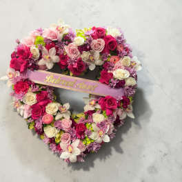 Heart-shaped floral wreath with pink and white roses and orchids