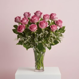Pink roses arranged in a clear glass vase with white filler flowers