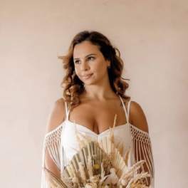 Woman in a white dress holding a dried flower bouquet