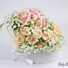 Bouquet of pale pink roses and baby's breath in a white box